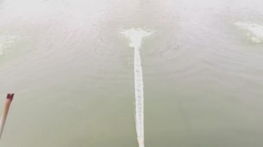 water flowing from PVC pipe line into the pond.