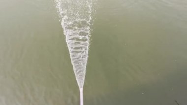 water flowing from PVC pipe line into the pond.