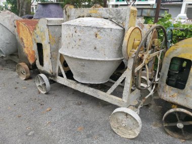 several old cement mixer machines left by the roadside.
