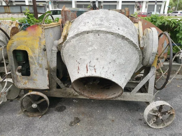 several old cement mixer machines left by the roadside.