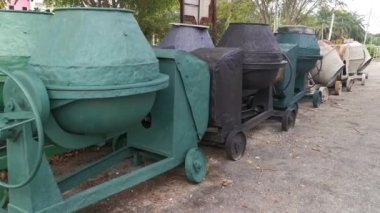 several old cement mixer machines left by the roadside.