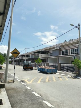 Perak, Malezya. 27 Eylül 2022: Çöp kamyonunun devrildiği sokak manzarası Taman Mas Konutu 'na taşınmak üzere beton döküntülerle dolu metal çöp konteynırını kancaya takıyor.