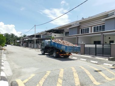 Perak, Malezya. 27 Eylül 2022: Çöp kamyonunun devrildiği sokak manzarası Taman Mas Konutu 'na taşınmak üzere beton döküntülerle dolu metal çöp konteynırını kancaya takıyor.