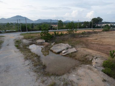 Kırsal cadde boyunca büyük çukur ya da su birikintisinin hava manzarası.