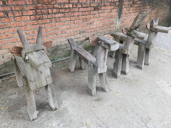 a row of wooden horse-shaped bench at the park