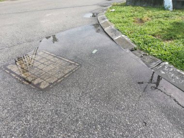 Yağmurdan sonra yol kenarında durgun su birikintisi