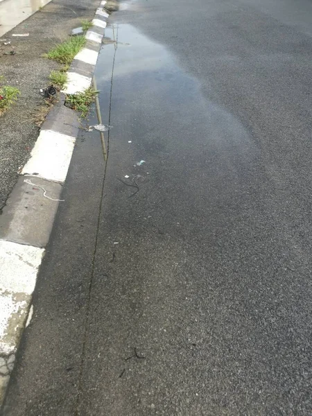 Pozzanghera Riflettente Con Acqua Stagnante Sul Bordo Della Strada Dopo — Foto Stock