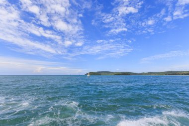 Mavi gökyüzü deniz ve dağ ile bulutlu 