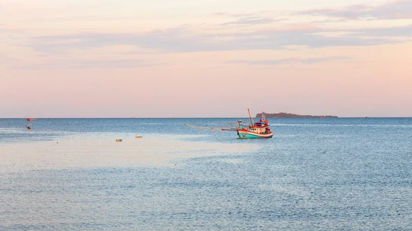 Pôr do sol com barco de pesca no mar — Fotografia de Stock