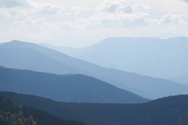 Uzak mesafe fotoğrafı, bir sürü pürüzsüz mavi dağ silueti.