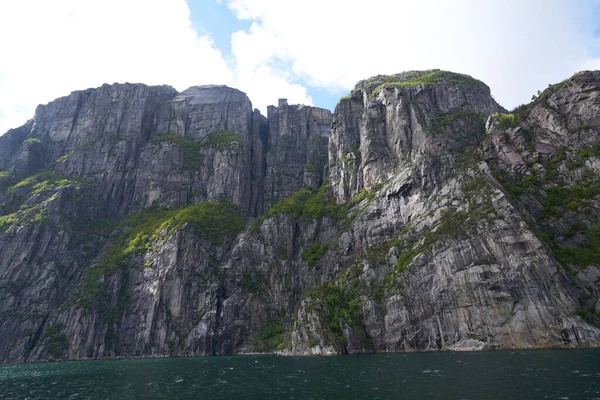 Preikestolen pulpit rock made of granite seen from below from the bottom of Lysefjord fjord and canyon in Norway
