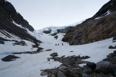 Arka planda Tur Rehberi, Norveç yakınlarındaki Buarbreen buzulunda yürüyüş.