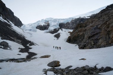 Arka planda Tur Rehberi, Norveç yakınlarındaki Buarbreen buzulunda yürüyüş.