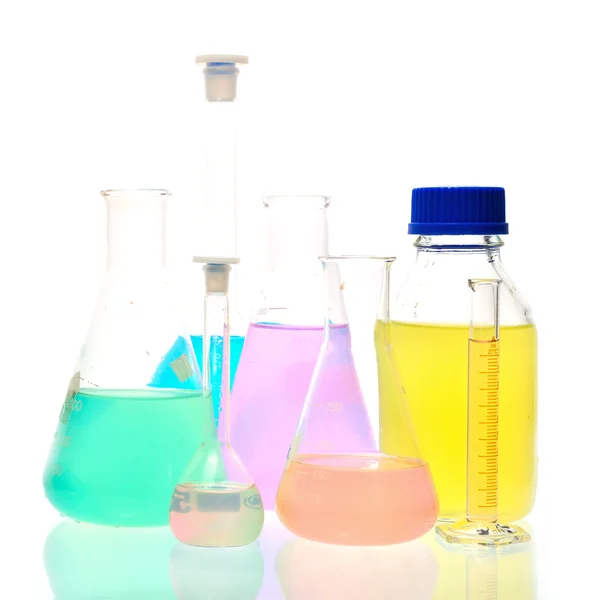 Volumetric laboratory glassware containing colored liquids — Stock Photo, Image