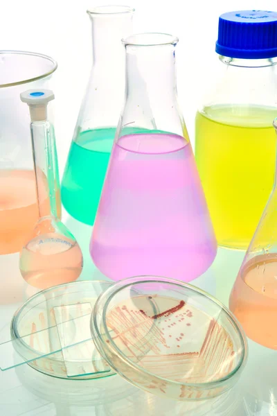 Volumetric laboratory glassware containing colored liquids — Stock Photo, Image