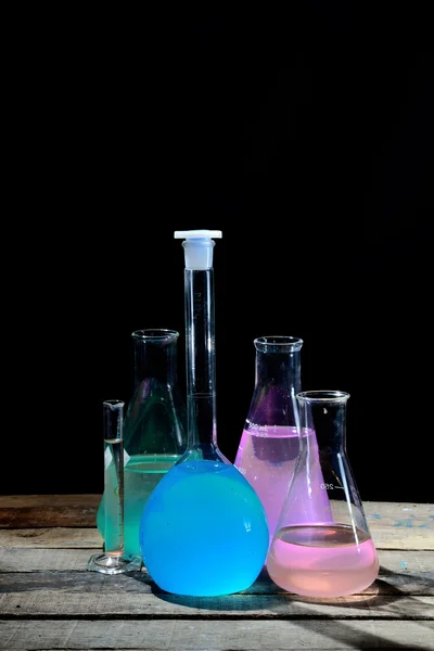 Volumetrische laboratoriumglaswerk met gekleurde vloeistoffen — Stockfoto