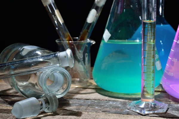 Volumetric laboratory glassware containing colored liquids — Stock Photo, Image