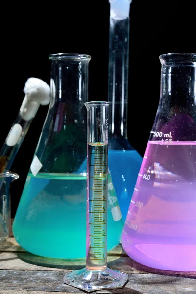 Volumetric laboratory glassware containing colored liquids — Stock Photo, Image