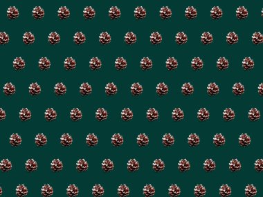 Noel kozalakları deseni. Yeşil arka planda yeni yıl süslemeleri. Düz yatış, üst görünüm.