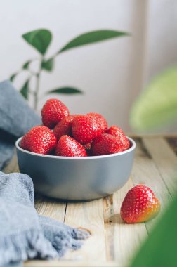 Yeşil yapraklı bir tabakta taze olgun çilek. Köyde sağlıklı bir kahvaltı için büyük kırmızı böğürtlen. Kırsal tarzda yemek fotoğrafı.