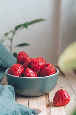 Yeşil yapraklı bir tabakta taze olgun çilek. Köyde sağlıklı bir kahvaltı için büyük kırmızı böğürtlen. Kırsal tarzda yemek fotoğrafı.