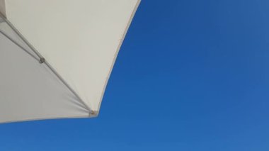 Parasol on the beach in slight breeze, view from below