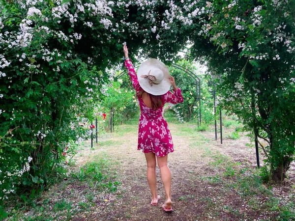 Young Woman Wearing Dress Hat Garden Full Colorful Roses — Stock fotografie
