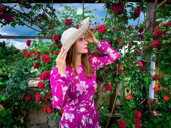 Young Woman Wearing Dress Hat Garden Full Colorful Roses — Stock fotografie
