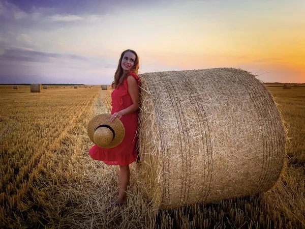 Woman Red Dress Straw Hat Standing Bales Hay Sunset — Stock Photo, Image