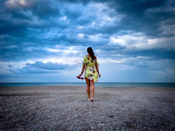 Zadní Pohled Ženu Žlutých Šatech Kráčející Pláži Zamračený Letní Den — Stock fotografie