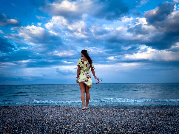 Zadní Pohled Ženu Žlutých Šatech Kráčející Pláži Zamračený Letní Den — Stock fotografie