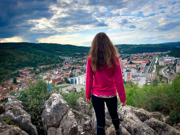 Frau Sportkleidung Blickt Von Einer Klippe Auf Die Stadt Herab Stockbild