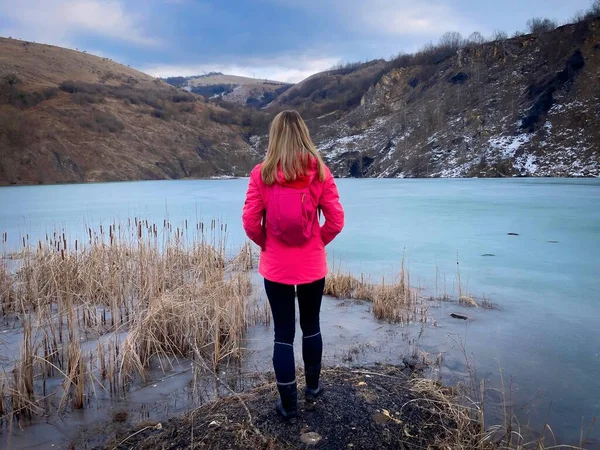 Rear View Woman Backpack Standing Frozen Lake Mountains 图库图片