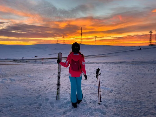 Skifahrerin Auf Der Piste Bewundert Den Sonnenuntergang lizenzfreie Stockbilder