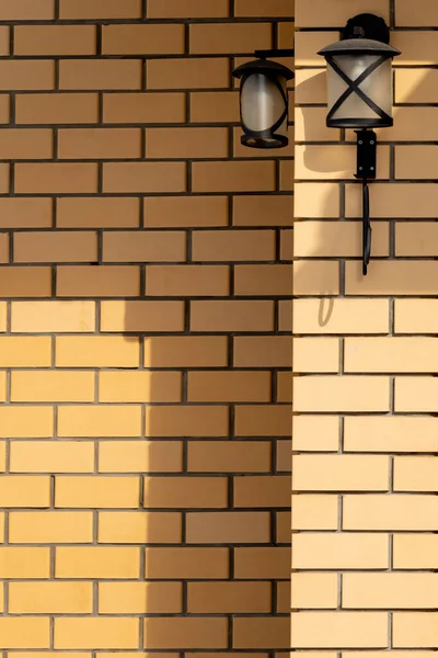 有两个街灯和影子的黄色砖墙 — 图库照片