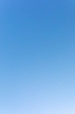 Açık mavi gökyüzü. Karanlıktan aydınlığa bir değişim. dikey kare