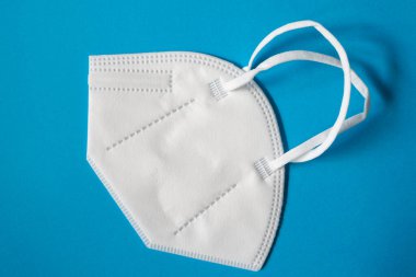 Mavi arka planda güvenli nefes alma maskesi var. Coronavirus önleme.