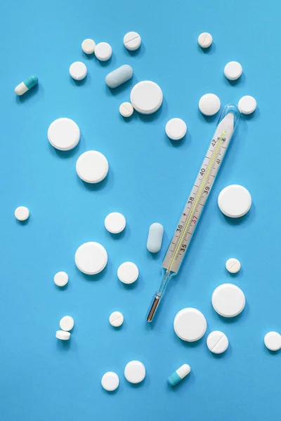 Medical Thermometer Lot Antipyretic Pills Antibiotics Blue Background Concept Danger — Stock Photo, Image