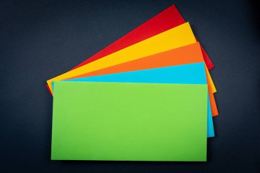 Çok renkli zarflar siyah arka planda bir pervaneye yayılmış. Boşluğu kopyala