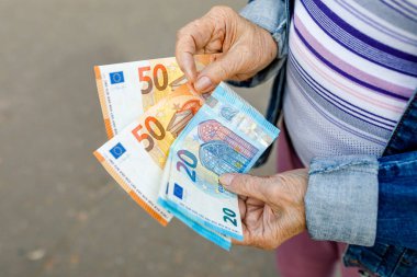 Avro banknotları olan yaşlı bir vatandaşın elleri, yaşlı vatandaş parasını sayıyor,