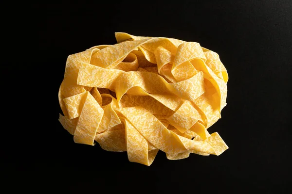 Macarrão Pappardelle Seco Não Cozido Isolado Fundo Preto Vista Superior — Fotografia de Stock