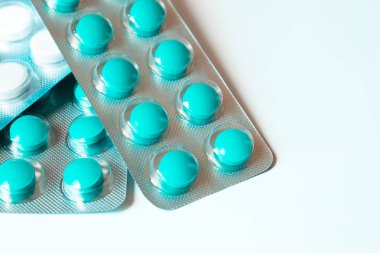 Beyaz arka planda yeşil ve beyaz haplardan oluşan üç kabarcık. Seçici odaklanma, yakın plan. Boşluğu kopyala
