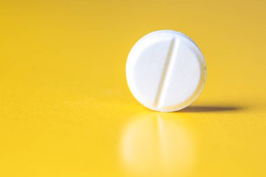 Sarı arka planda büyük beyaz bir tablet. Boşluğu kopyala