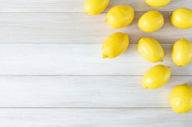 Beyaz ahşap arka planda olgunlaşmış limonlar. Metin için alanı kopyala