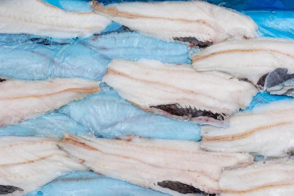 frozen fish Longtail hake in a box. Packaging with interleave plastic film and fish. Argentine tradel fish, after primary processing on a trawler, is ready for sale