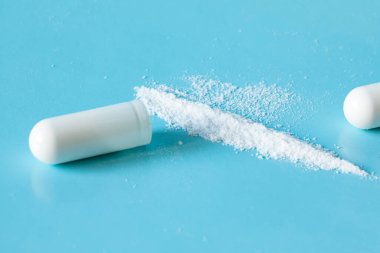 Beyaz toz, ilaç ya da ilaç kapsül kabuğundan döküldü. yakın plan
