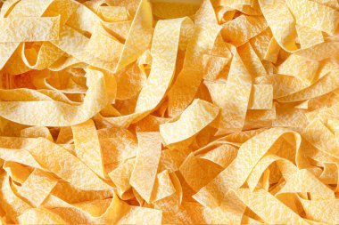 Pişmemiş Çiğ Organik Pappardelle Makarna dokusu arka planı. Kastır buğday gurmesinden makarna ve sağlıklı yeme konsepti. yakın plan