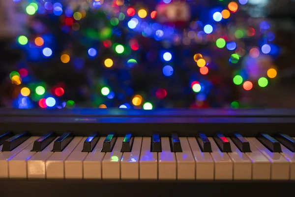 Piyano klavyesi ve Noel ağacı aydınlatmaları. Canlı renkler, tatil konsepti
