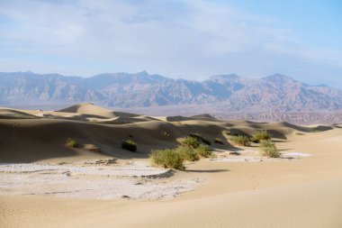 Mesquite Kum Tepeleri, dağlar ve bulutlu gökyüzü arka planı Ölüm Vadisi Ulusal Parkı, Kaliforniya