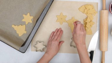 İçinde ahududu reçeli tarifi olan noel kurabiyeleri, pişirme süreci, düz yatak. Şef pipet kullanarak kurabiye merkezinde delikler açıyor.